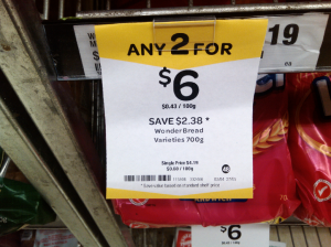 Supermarket price tag showing unit pricing in fine print