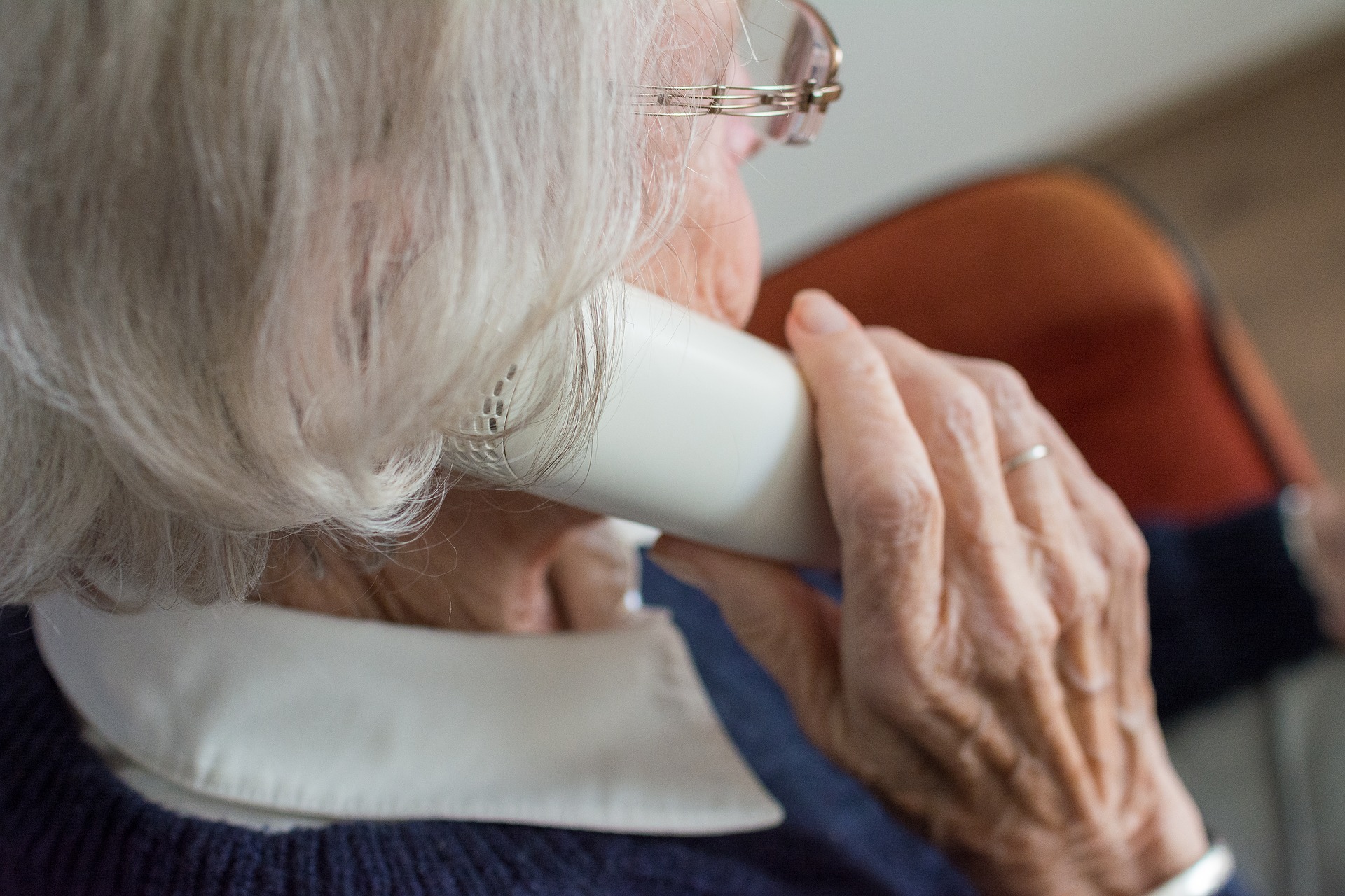 Elderly adult holding telephone to ear