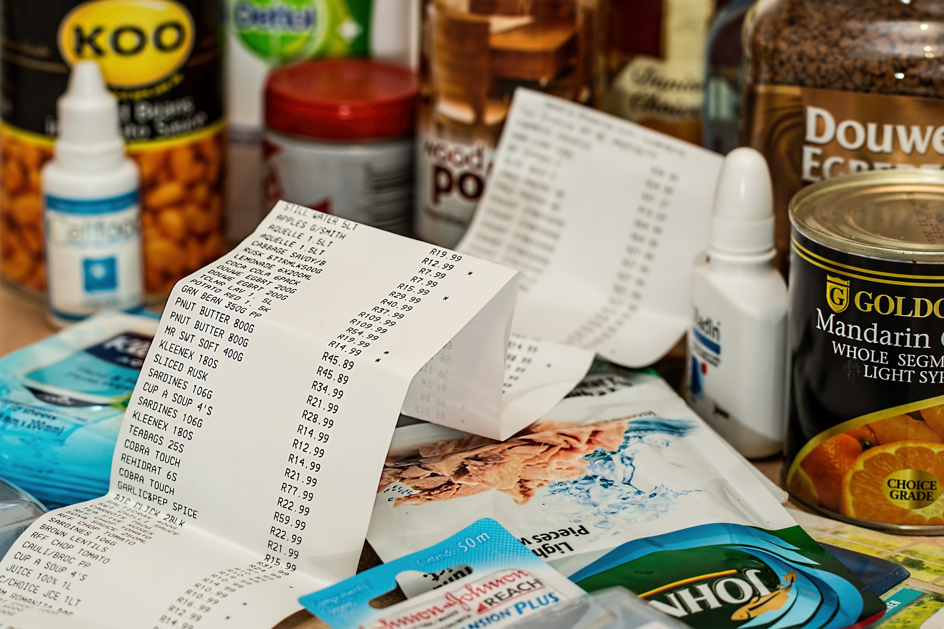 A receipt for grocery items. In the background are grocery items