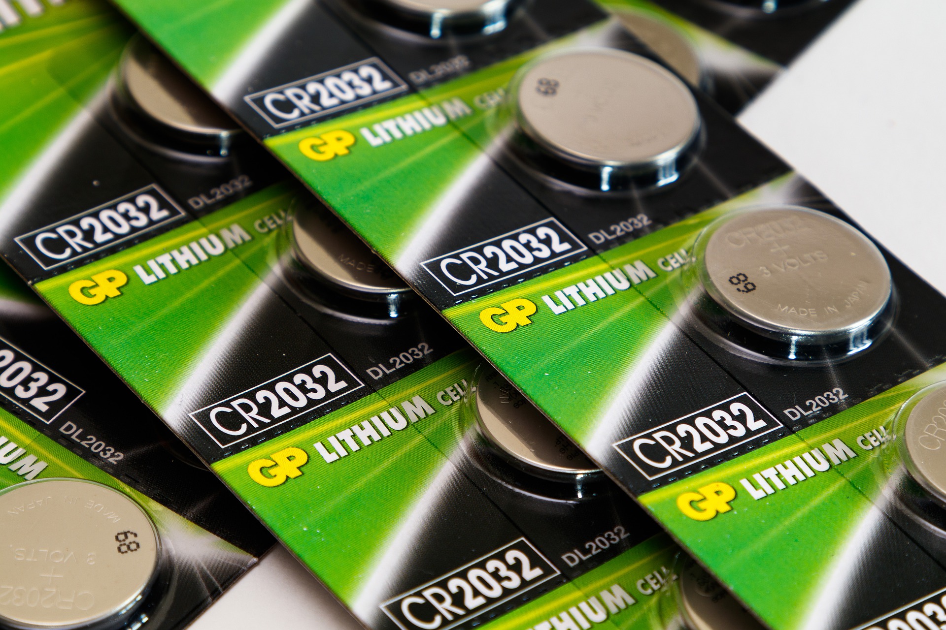 Small round disk batteries in green and black cardboard packaging that says 'GP Lithium'
