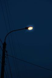 A solitary street lamp illuminates the night, creating a moody urban atmosphere.