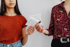 Two women exchanging sanitary pads, highlighting menstrual health awareness.